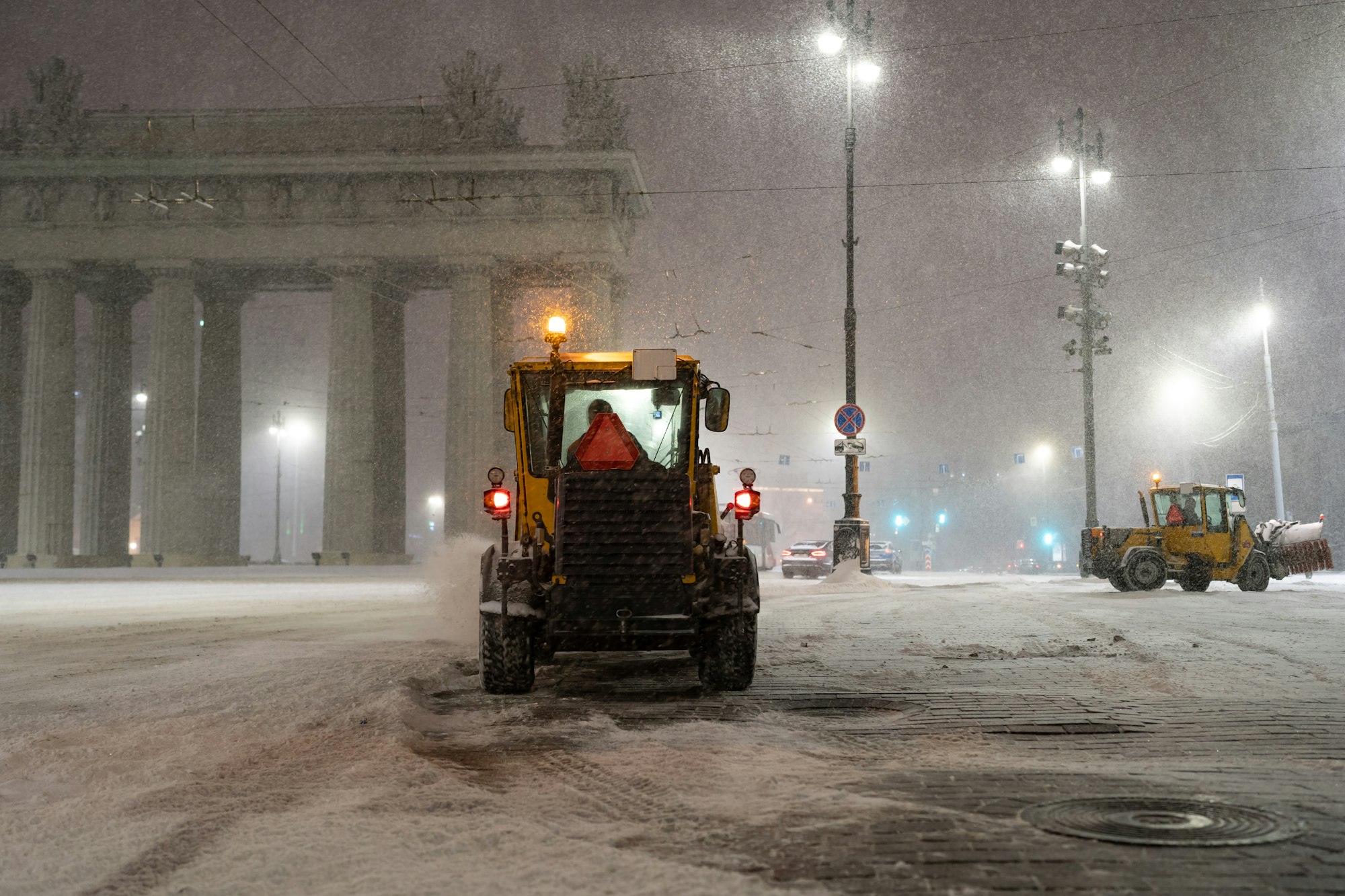 Snow removal vehicles work in city after snowfall. Tractors, bulldozers and snowblowers clean street
